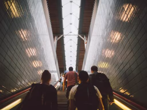 Group of diverse commuters walking up a tiled stairway in Berlin station. Management, cadres, dirigeants