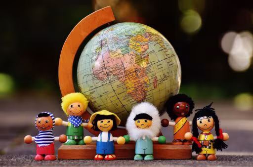 IA et réduction des effectifs : figurines en bois de toutes nationalités réunies autour d'un globe