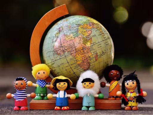 IA et réduction des effectifs : figurines en bois de toutes nationalités réunies autour d'un globe